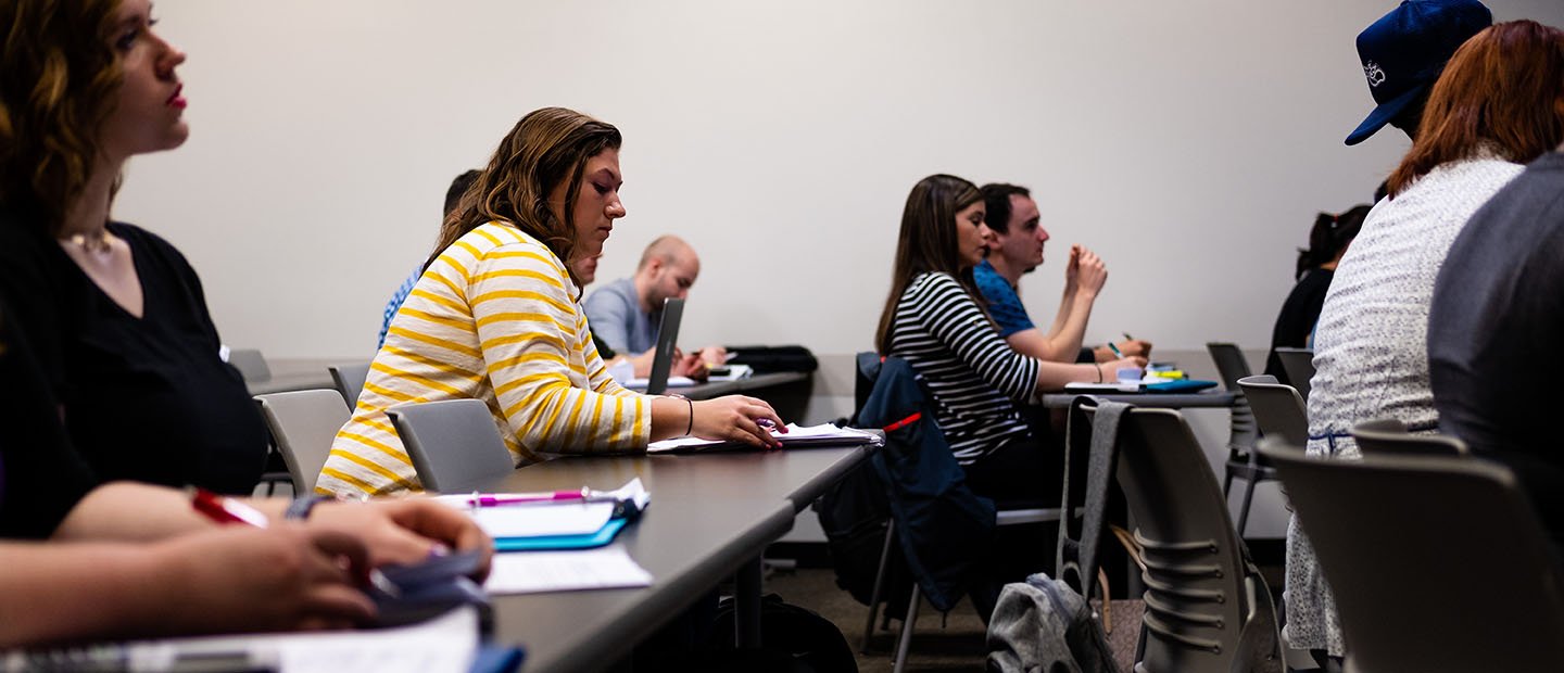 students seated at desks with note pads