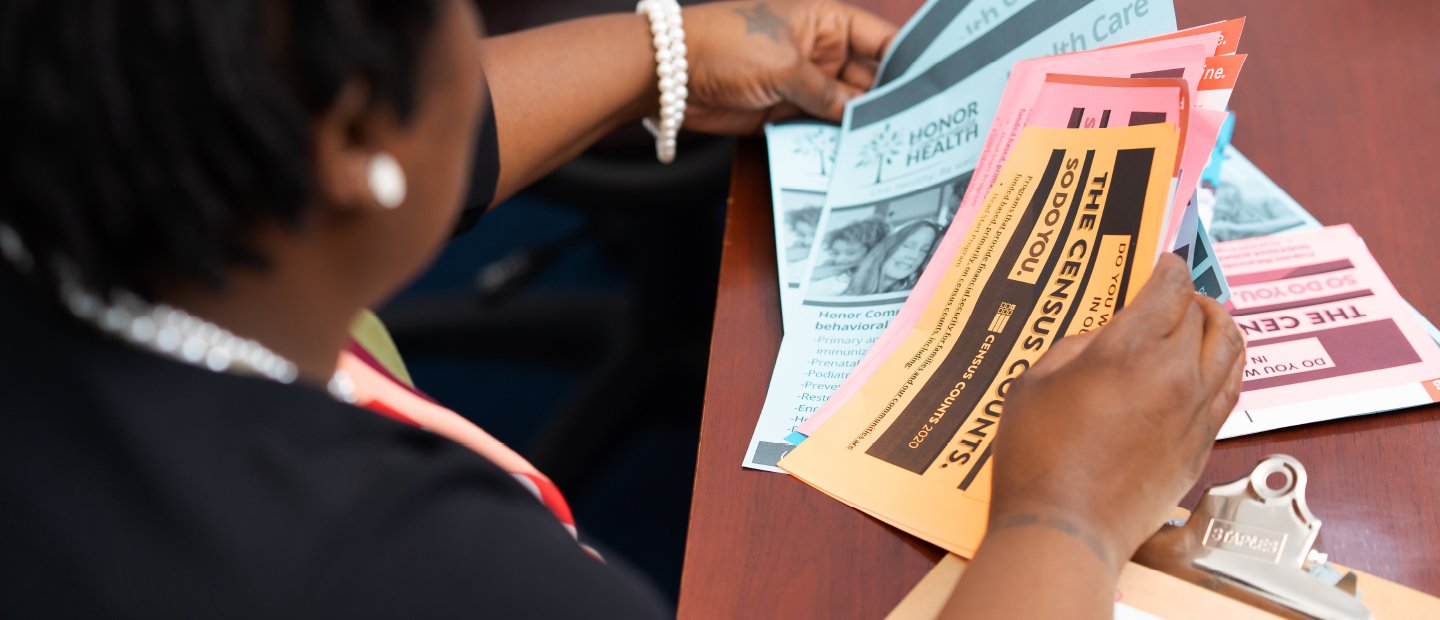 Nonprofit Management Certificate A woman seated at a table, looking through Census and health care flyers.