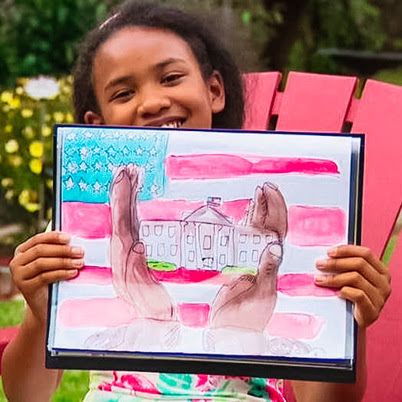 Gabby Faisal holding her drawing of the White House.