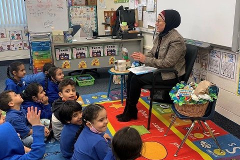 Nawal Hamadeh, reading to students in a classroom at Universal Academy.