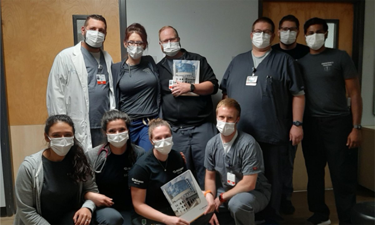 A group of nurses wearing face masks, posing for a photo