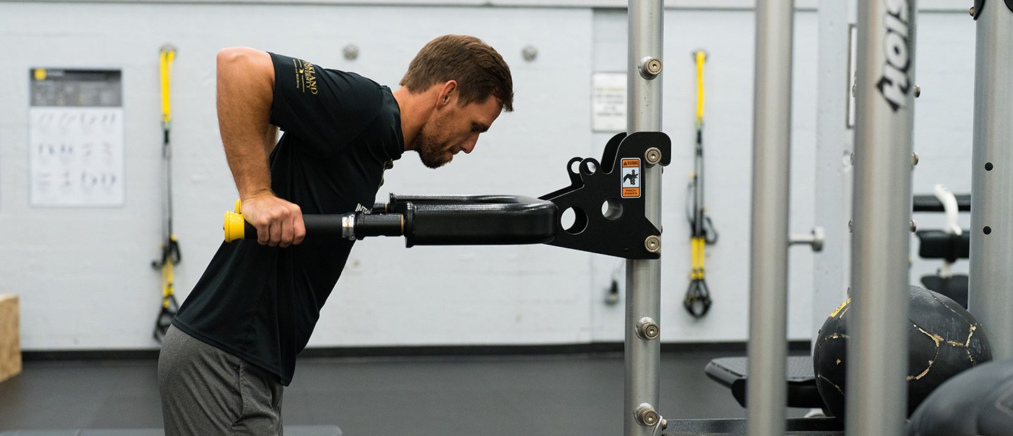 A man doing tricep dips on a machine in the recreation center.