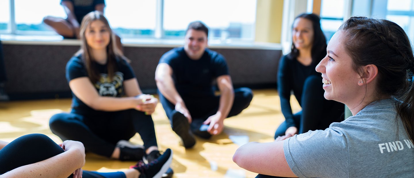 People seated in a group exercise studio.