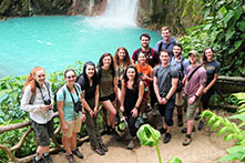 Group of students standing in front of waterfall