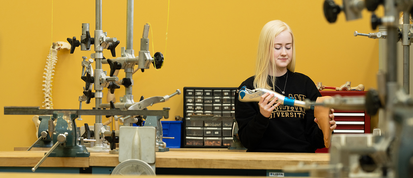 Orthotist and Prosthetist Assistant Studies image of a young woman holding an orthotic foot and ankle brace