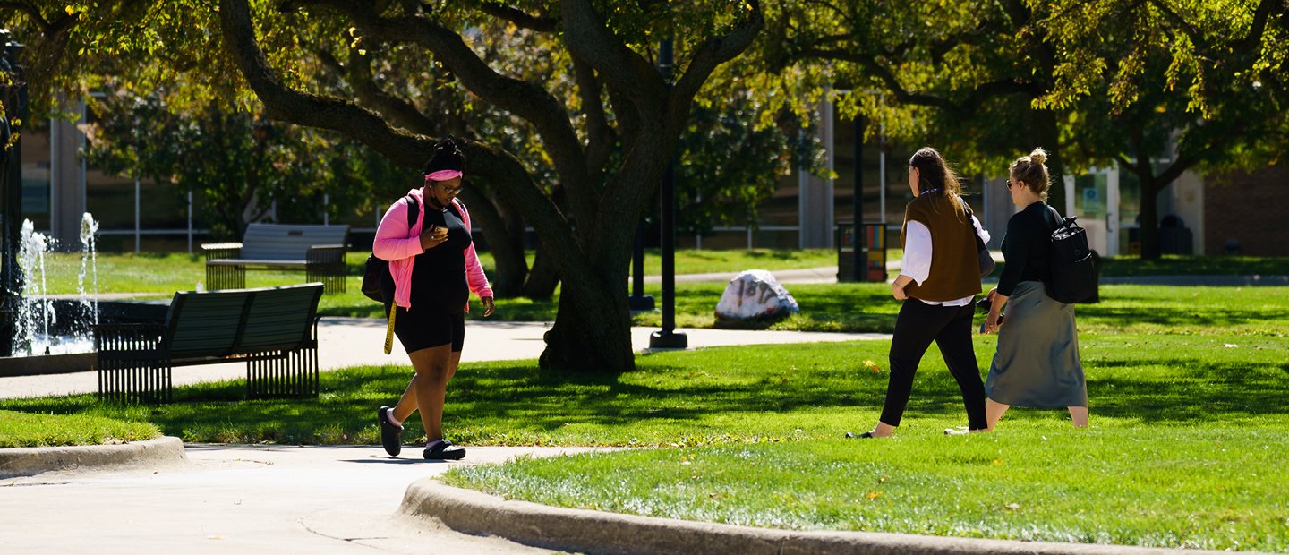 Students walking in front of a fountain on Oakland University's campus in Summer.