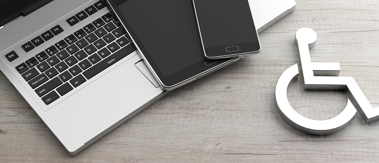 A laptop with two different sized smart phones on it and a symbol of a person in a wheelchair next to it.