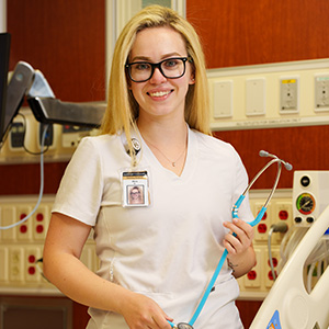 BSN student, Olivia, holding a stethoscope in a lab.