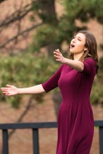 MTD student, Angela, singing with her arms spread wide.