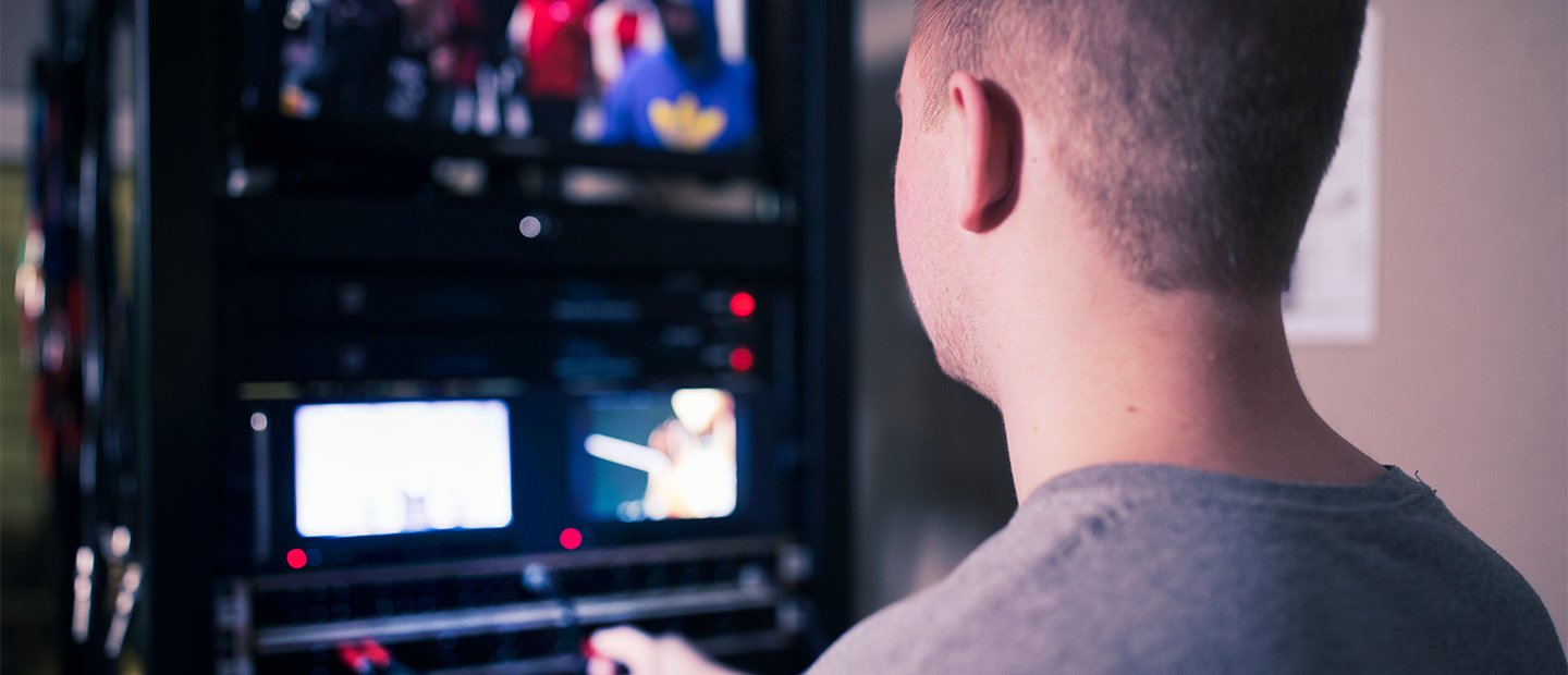 A man sitting at a computer, editing video. 