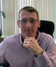 Greg Giberson, seated at a desk in an office.