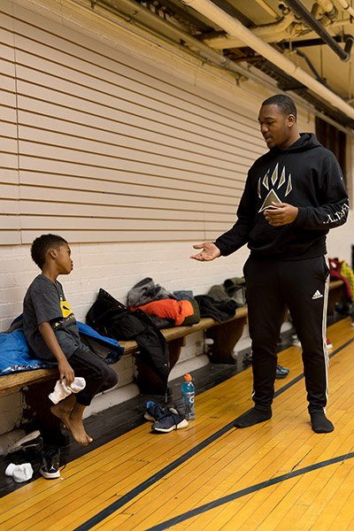 Coach talking to a young player sitting on the bench
