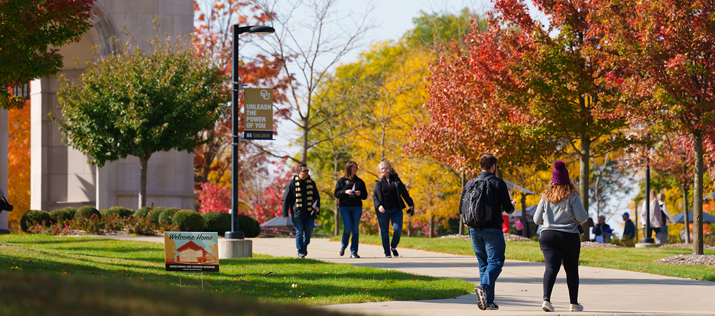 Banner with students walking outside on sidewalk