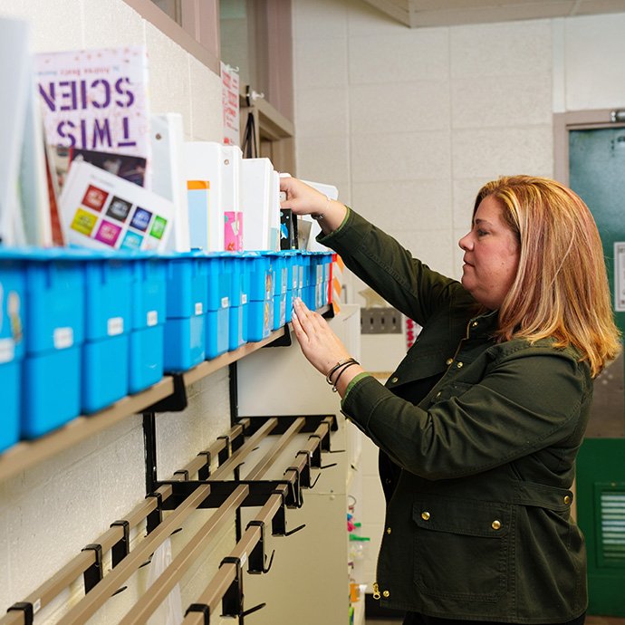 A teacher booking books in tubs
