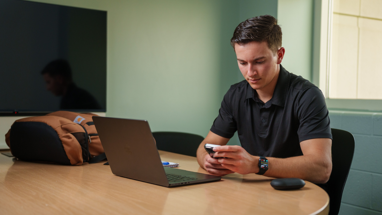 MBA student at table with laptop