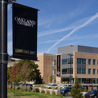 A light pole with a banner at Oakland University