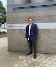 Zach Allison standing in front of an Ally building