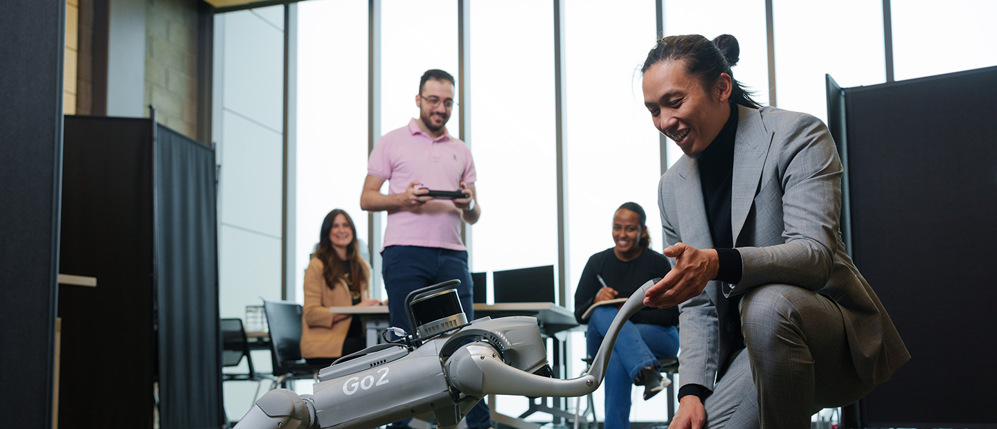 Four people working with a remote controlled robot