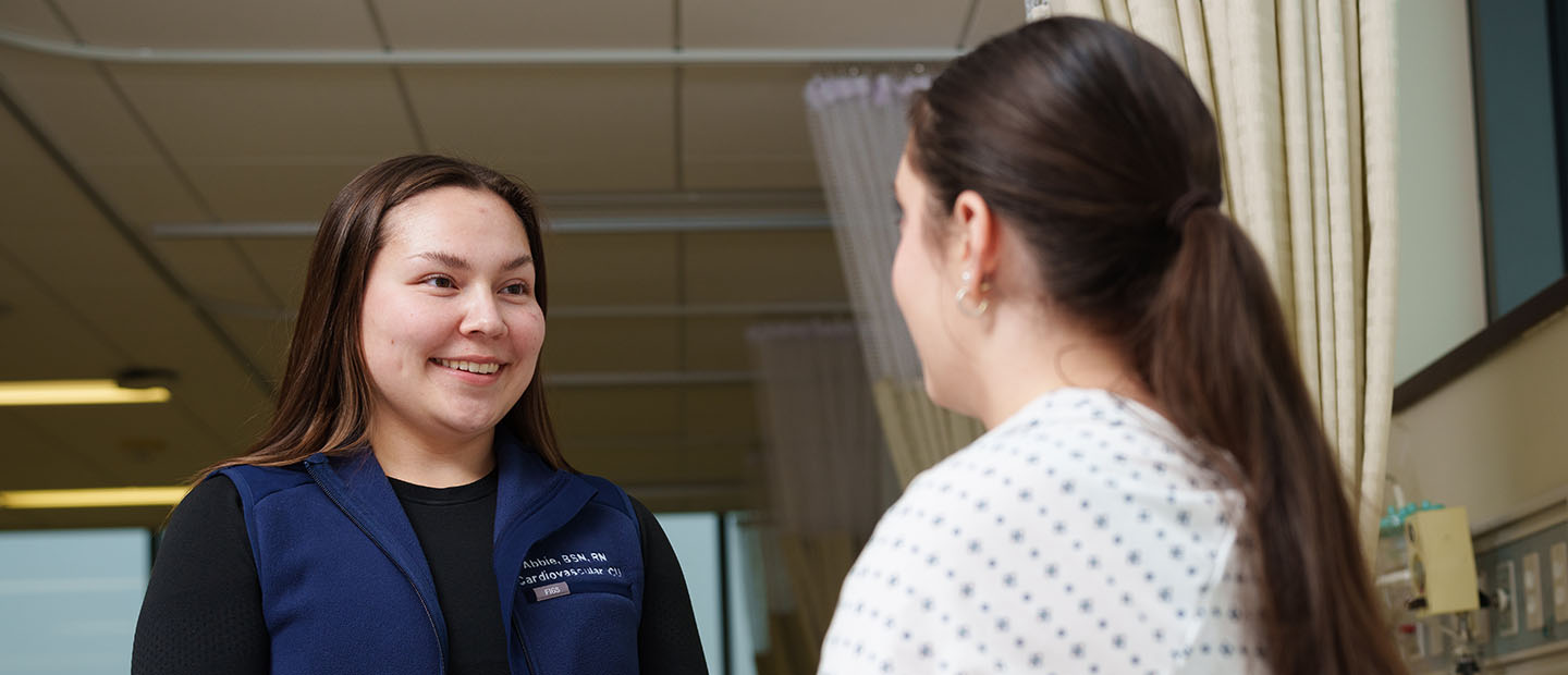 Female nurse speaking with a female patient.