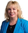 Headshot: Blonde woman in Blue Jacket with dark top
