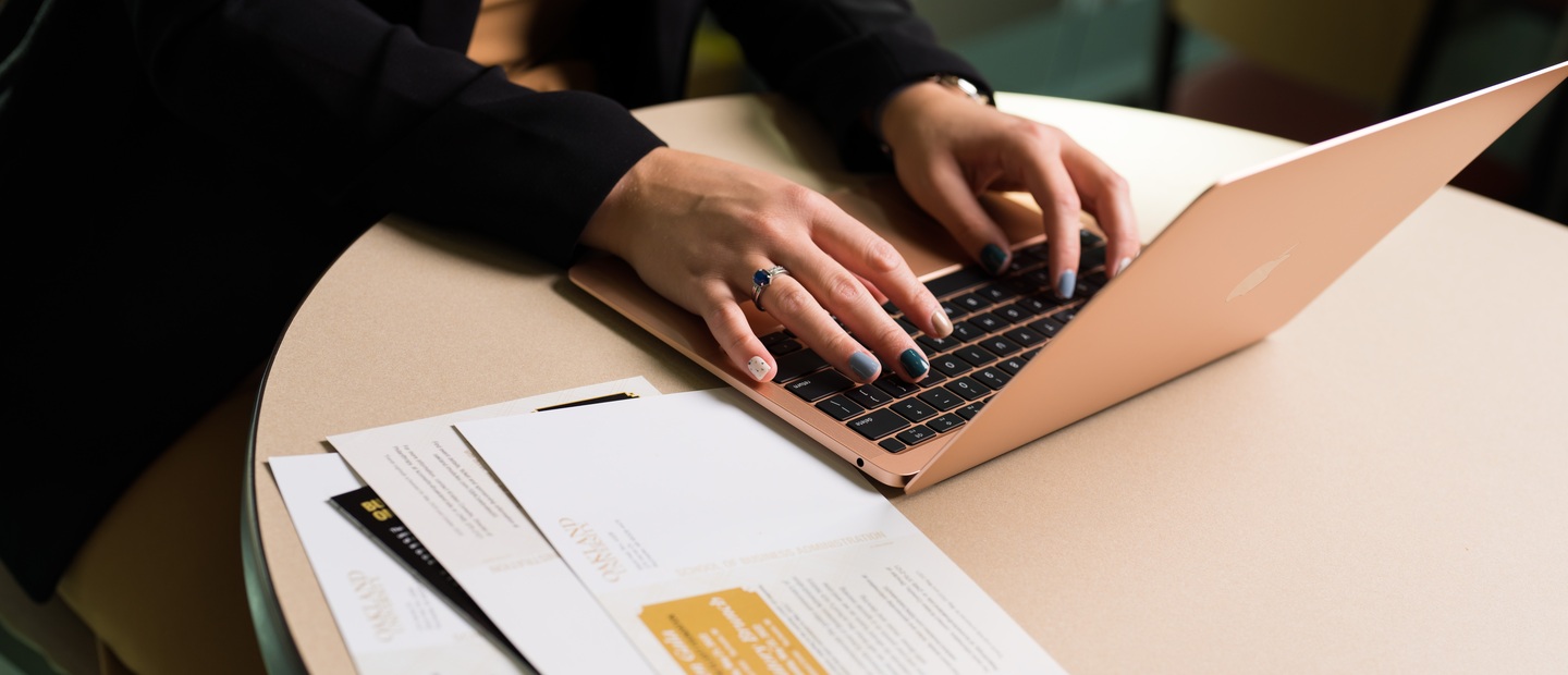 Hands typing on a laptop