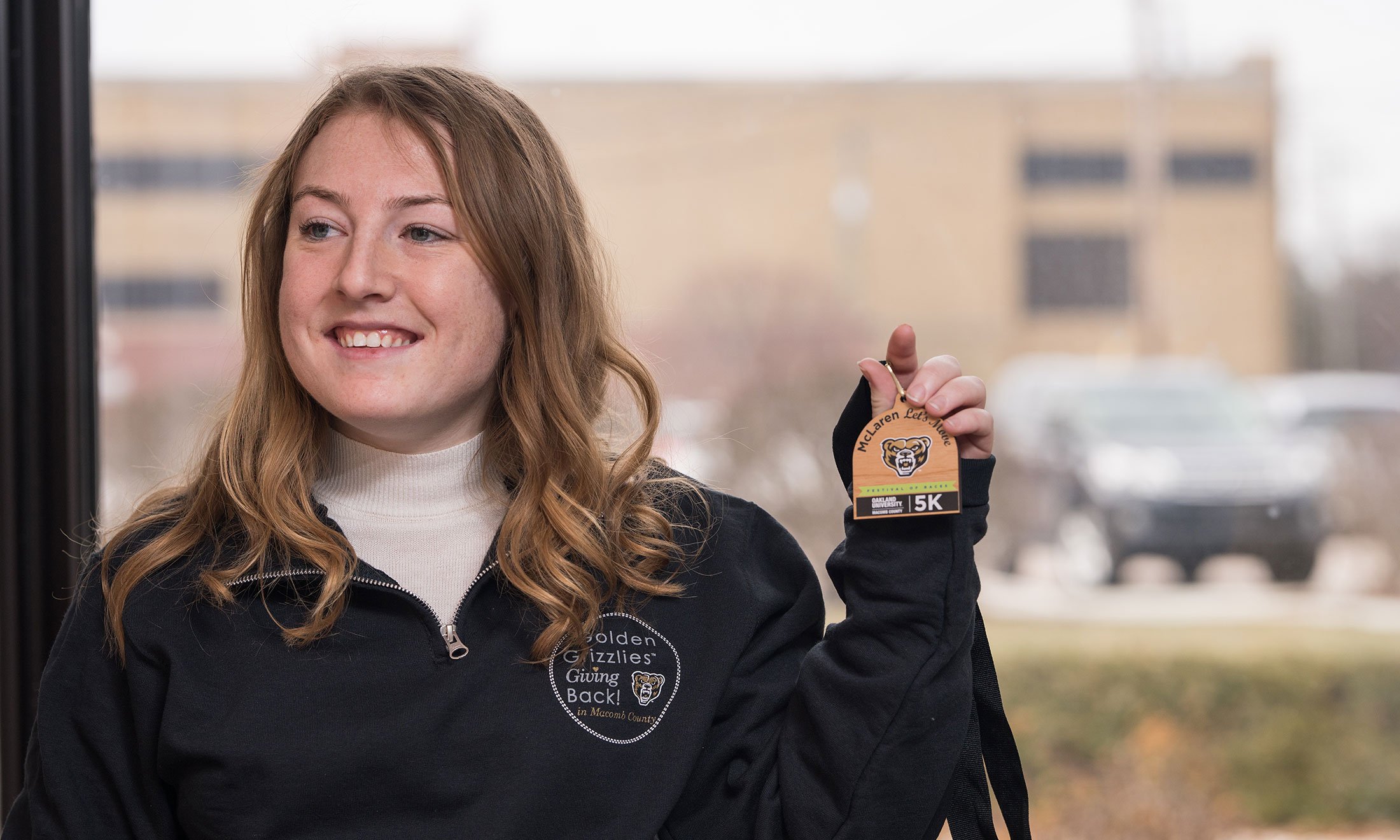 A woman holding a medal.