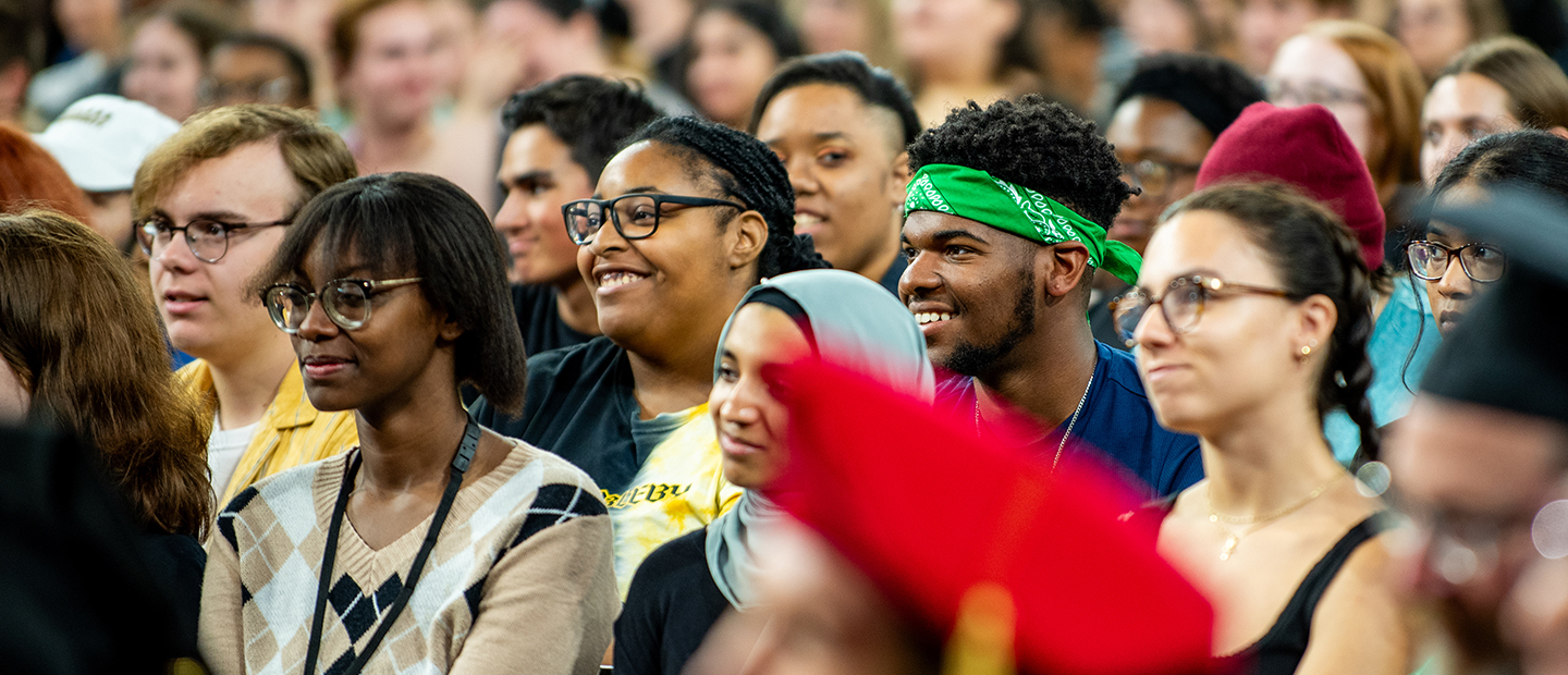 A crowd of young people stands together smiling