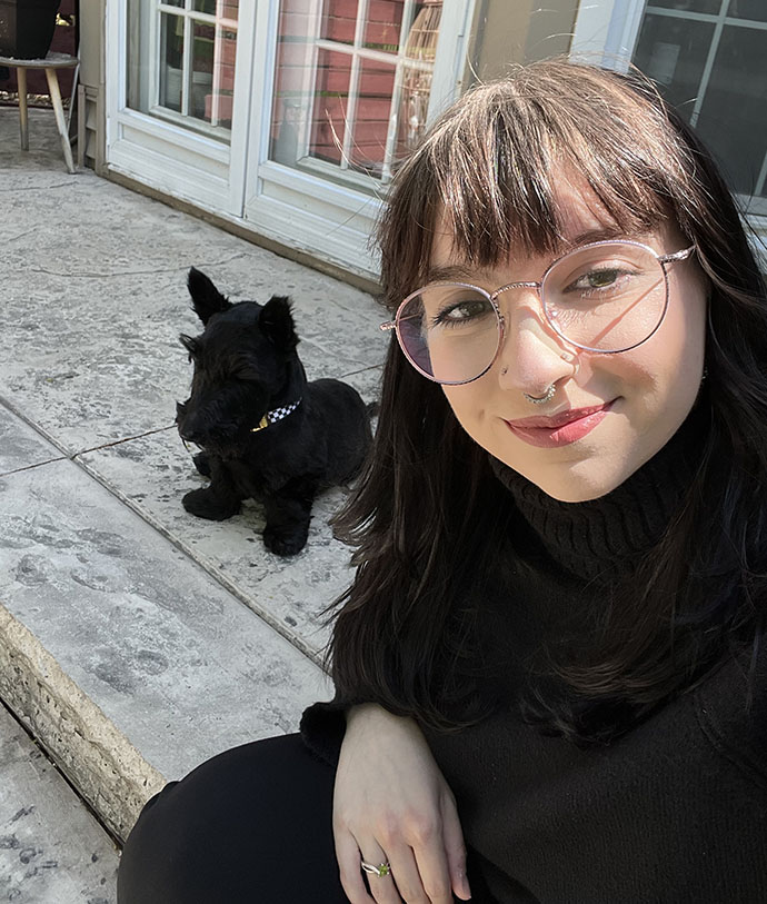Sophia Vecchi poses for a photo in front of an outdoor cat.