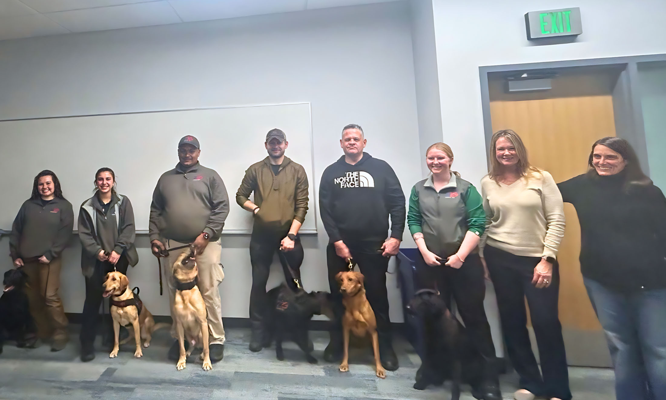 Students and police officers pose for a photo with the dogs.