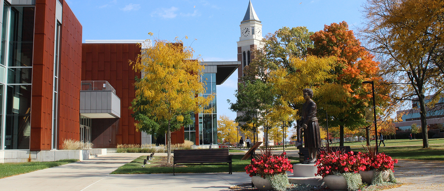 Oakland University campus in fall, with the Elliott Tower and a statue of Matilda Dodge Wilson.