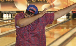 A student celebrates while bowling