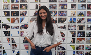 A student in front of OUWB's photo wall