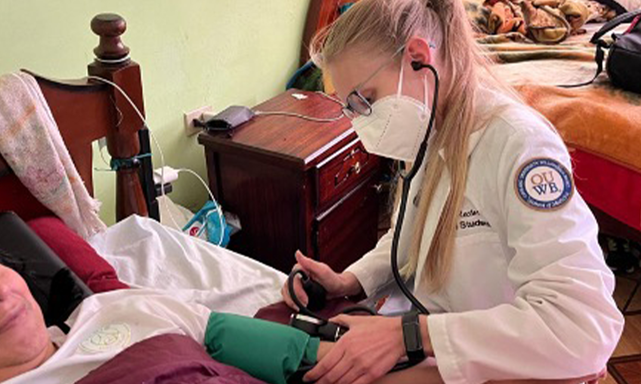 Dana Rector, M.D., OUWB '23, in Ecuador, 2023 helping a patient can’t get to the clinic very easily