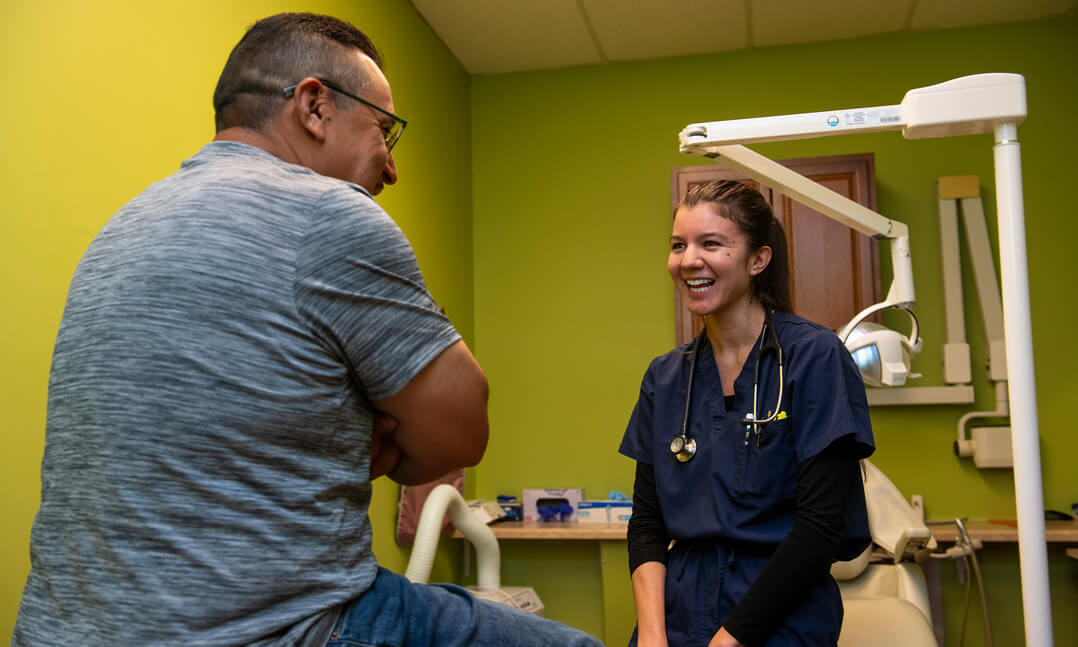 An image of an OUWB student and patient talking