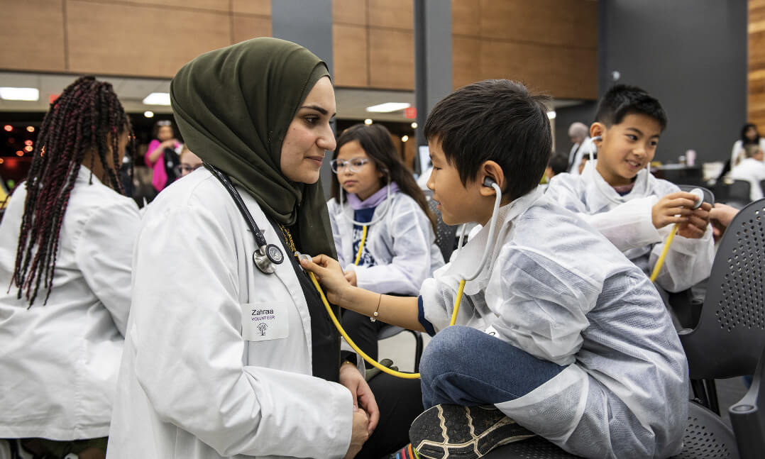 An image of an OUWB student and a Reach Out to Youth participant