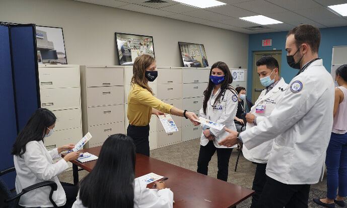 Sarah Provencher hands out informational pamphlets during a recent orientation