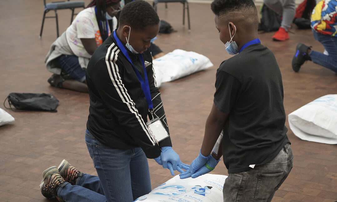 An image of two younger students training with the CPR pillowcase