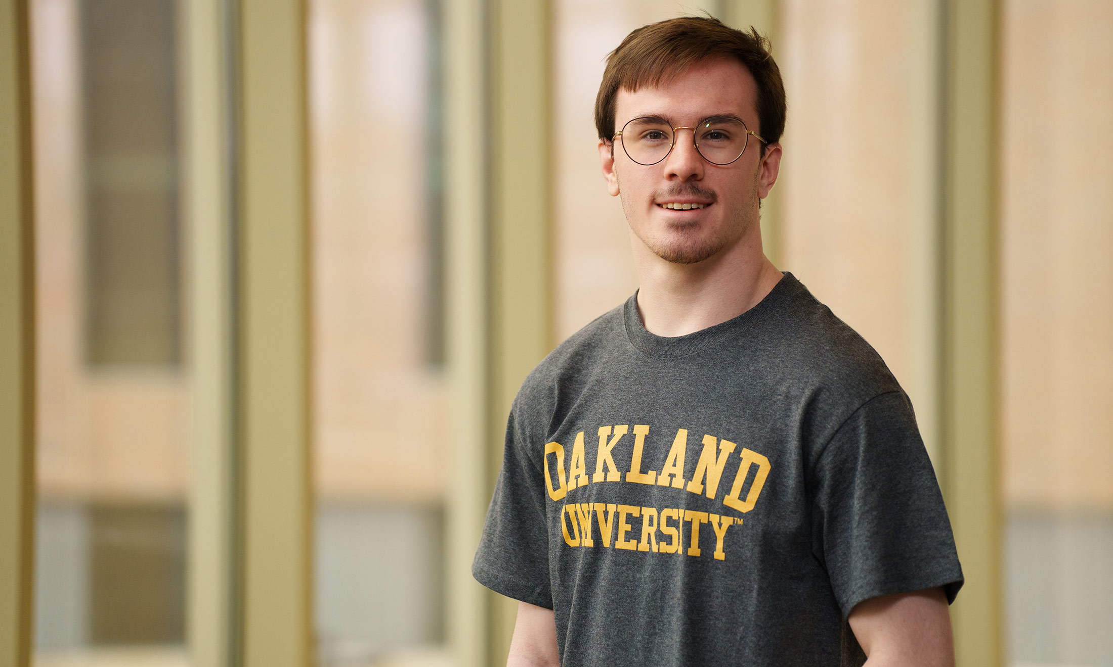 Kyle Spengler wearing an Oakland University shirt and smiling