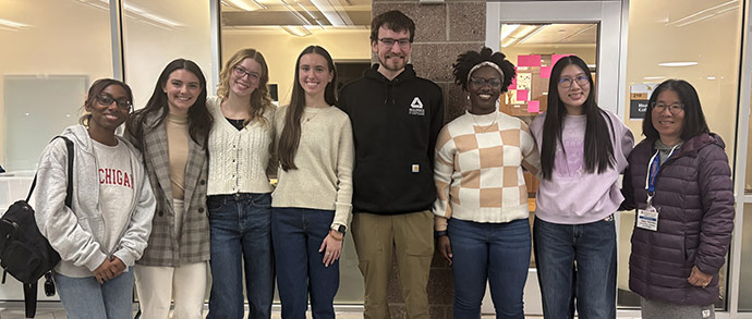 A group of students and professionals smile