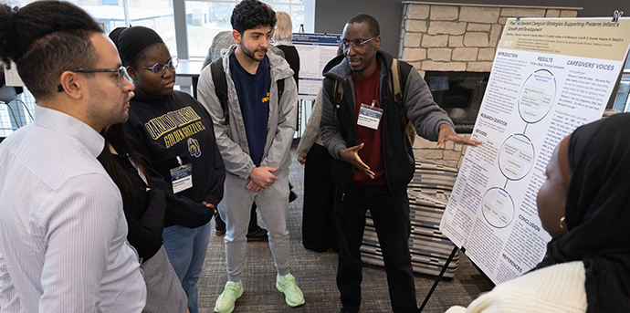 A student discusses research with a group