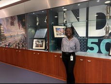 Student standing in front of a bookshelf