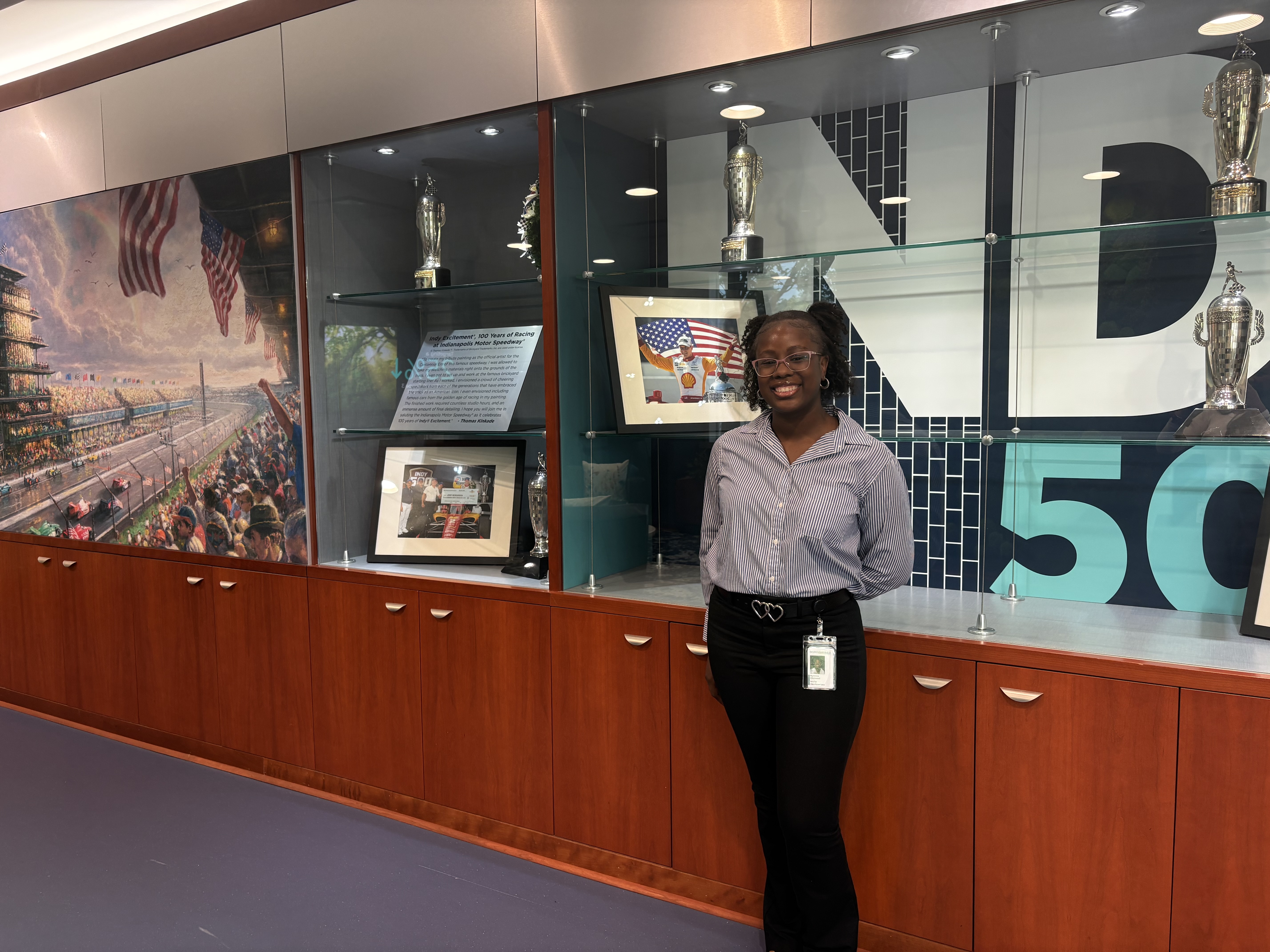 Student standing in front of a bookshelf