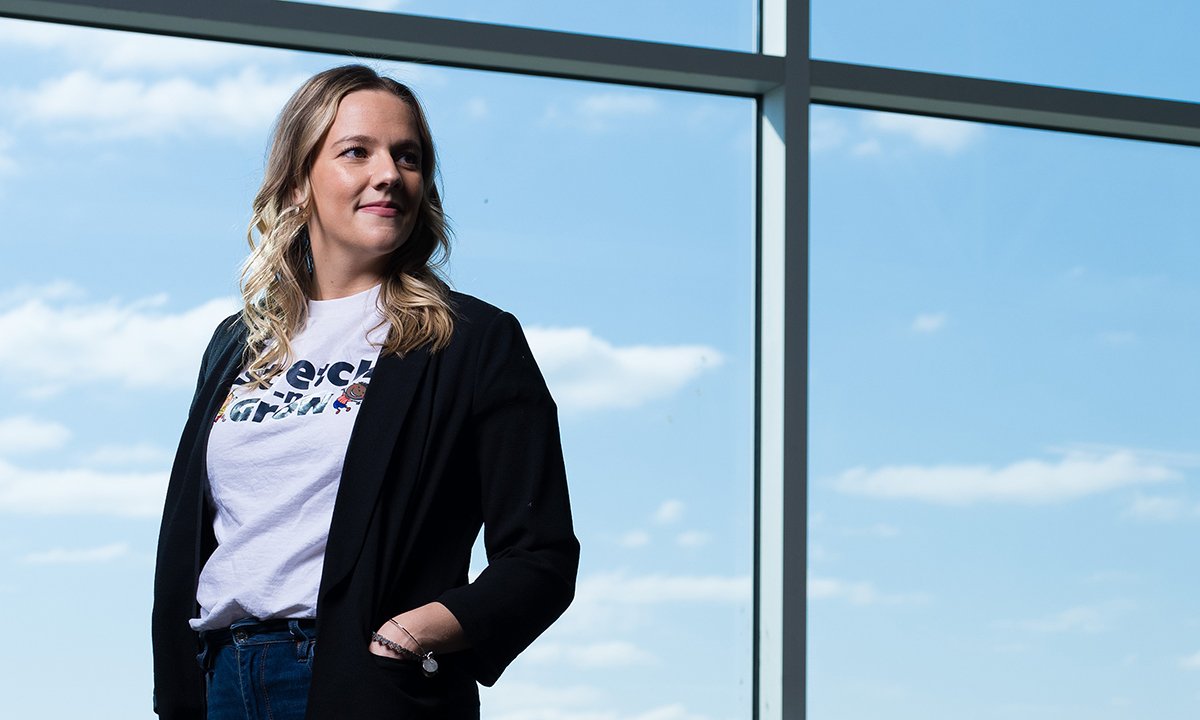 Woman standing in front of a large window.