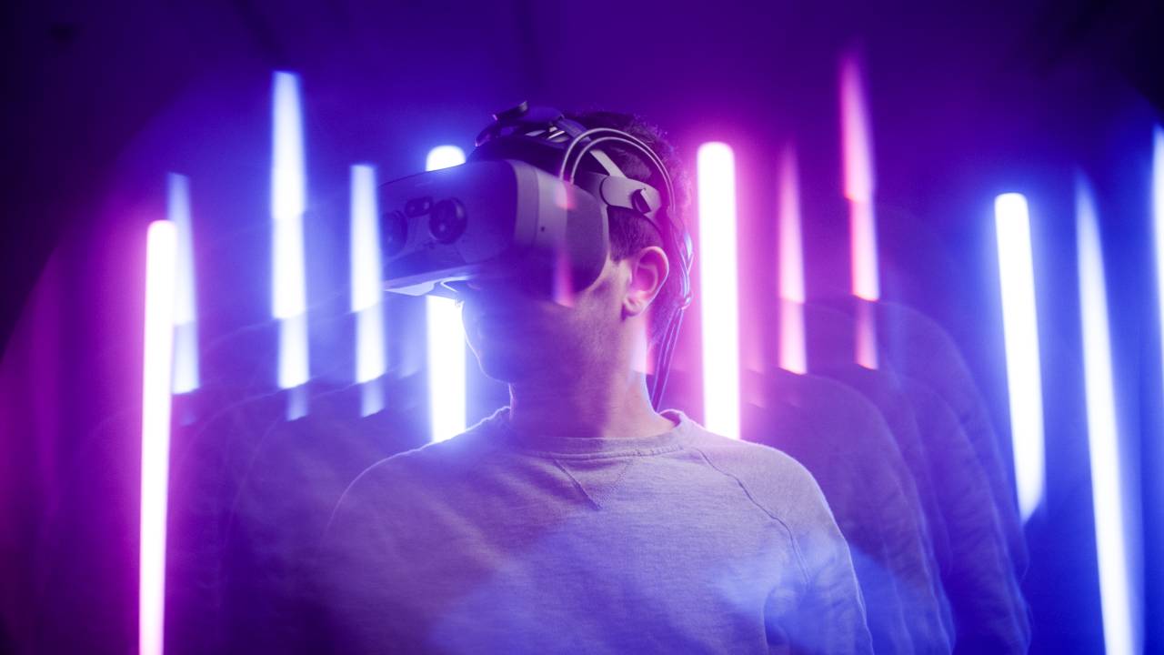 Student wearing VR goggles surrounded by lights