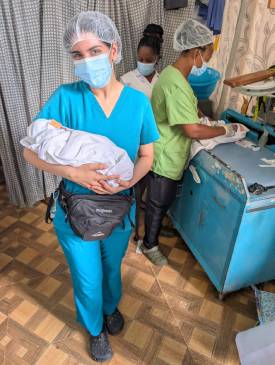 OU student Nedi Affas holding a baby