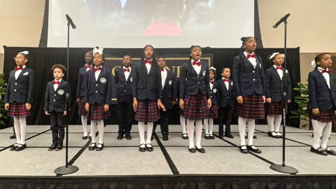 A graphic that has the DAAS Choir performing on a stage