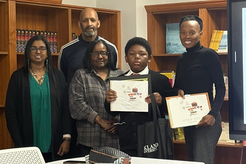 A book writing contest winner and staff posing for a photo.