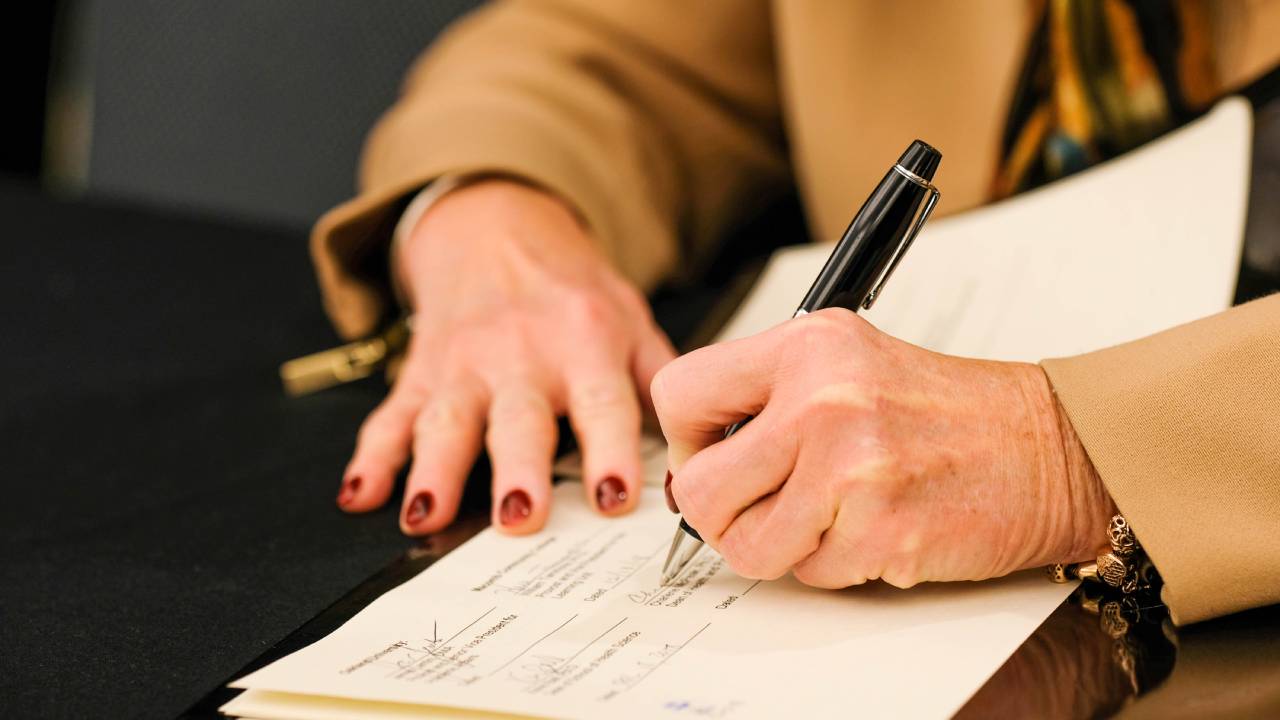 Hands with pen signing articulation agreement