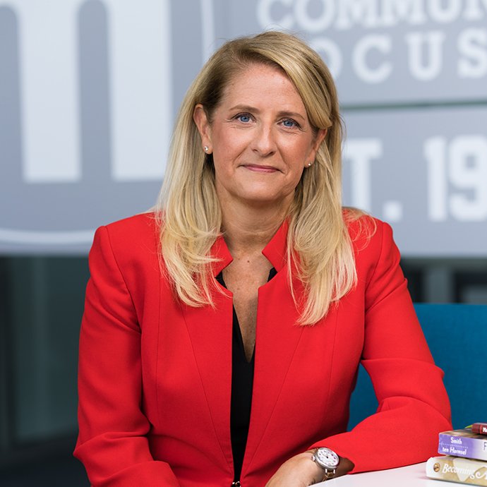 A woman smiling at a desk.