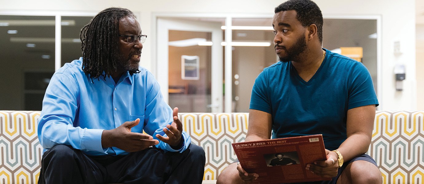 Two men sitting and talking.